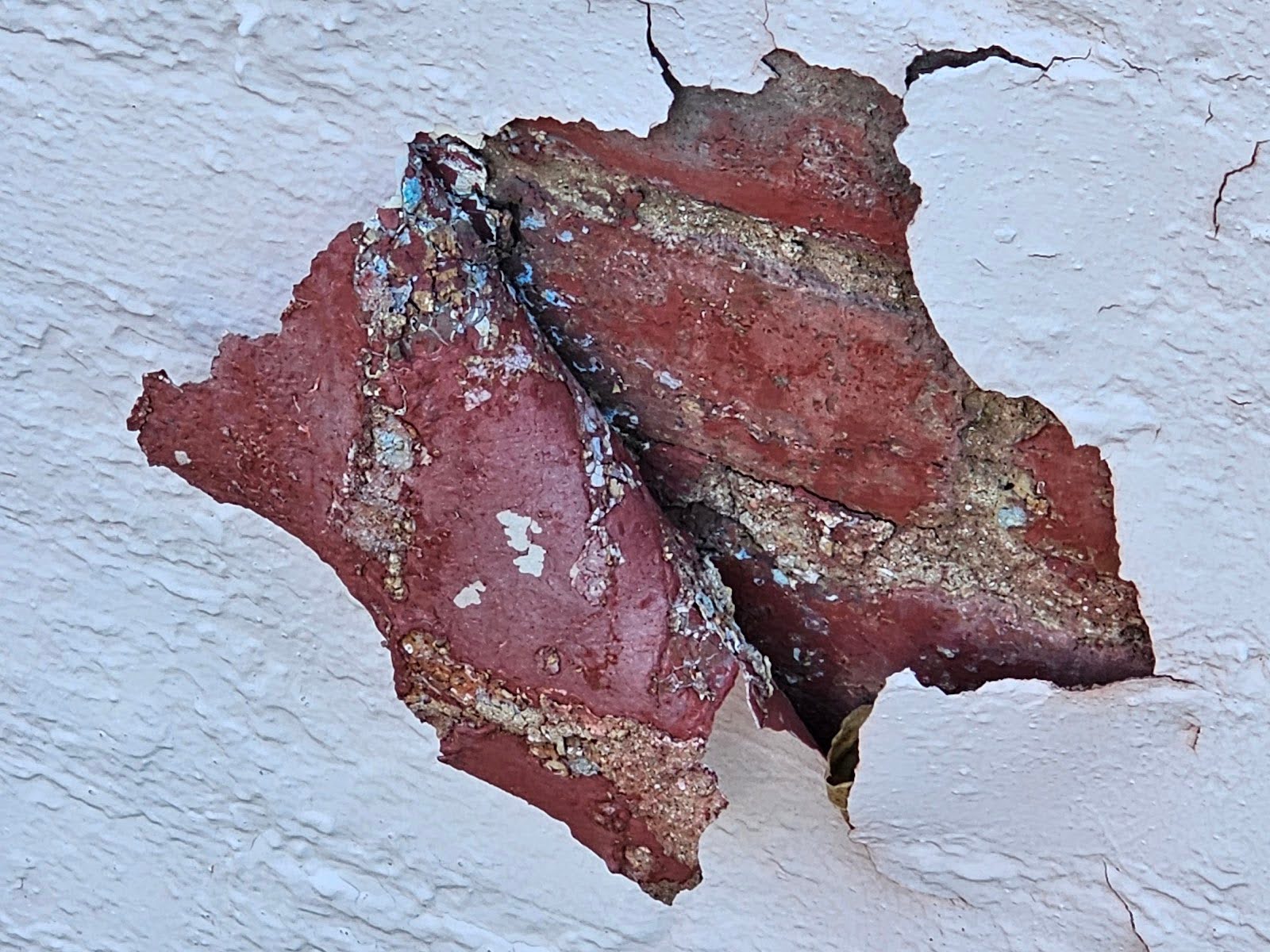delaminated from the brick substrate.