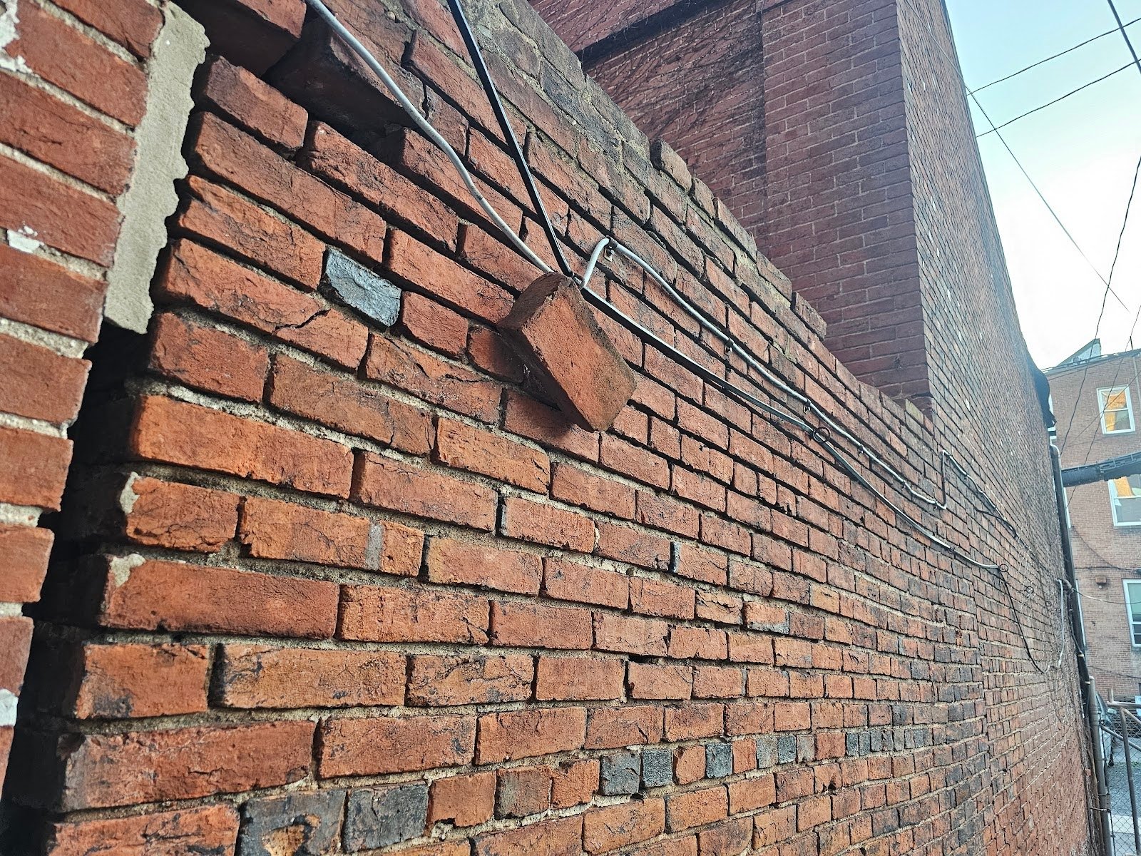 Close-up of building separation in historic brick wall in DC row home