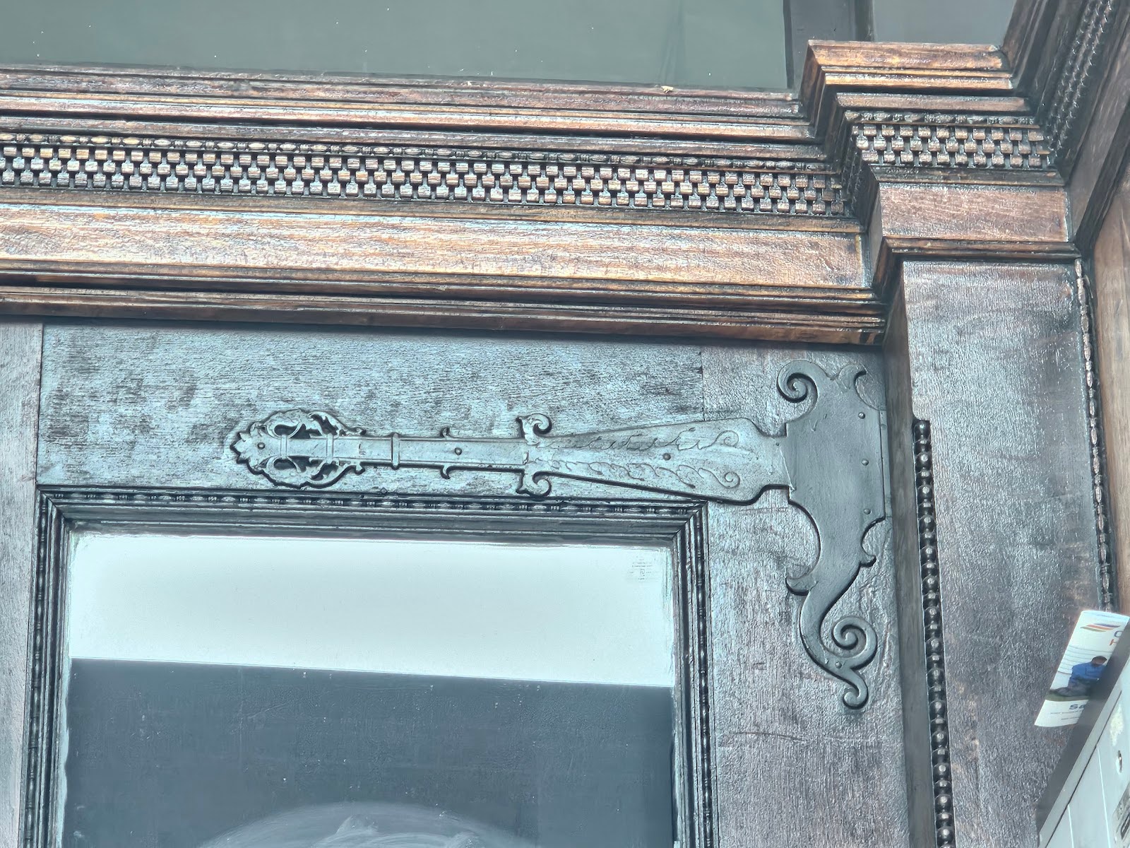 Decorative strap hinges on an old brick building