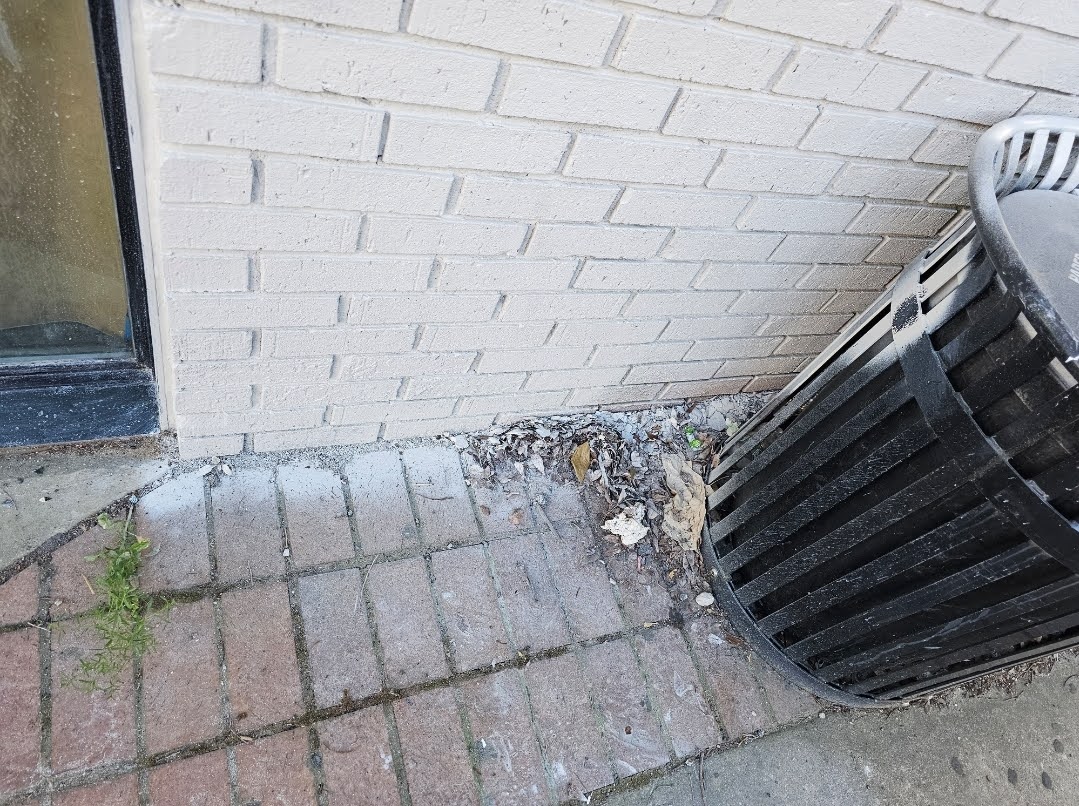 Overspray marks visible on painted brick facade during restoration work