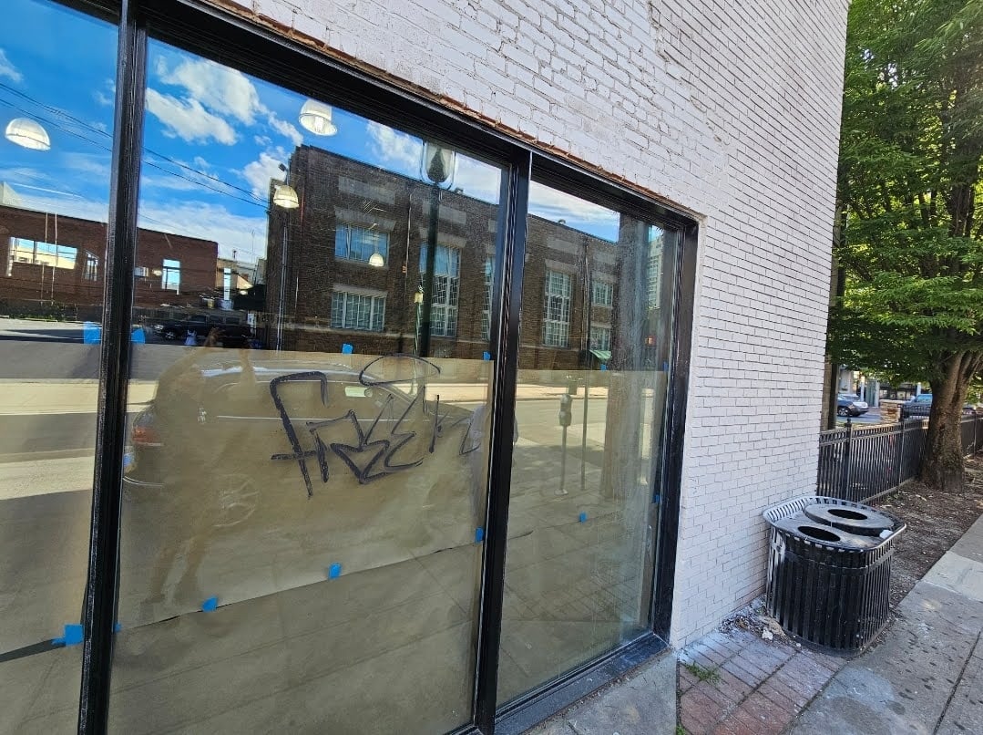 Overspray on painted brick facade with visible surface details