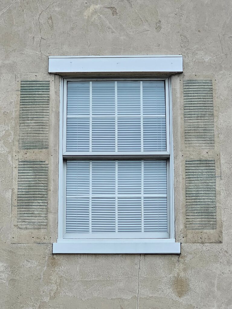 Painted outline of the shutters on the wall