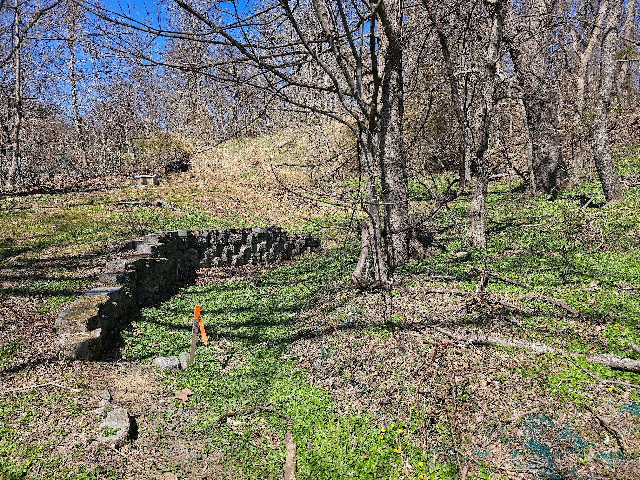 it retains soil at a higher elevation on the upper loaded side of the wall
