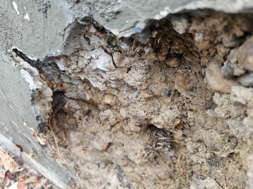 Damaged retaining wall with visible cracks and shifting